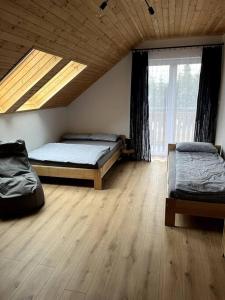 a bedroom with two beds and a skylight at Nowy apartament dla 6 osob in Krynica Zdrój