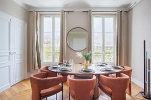 een eetkamer met een tafel en stoelen en een spiegel bij Apartment Bastille by Studio prestige in Parijs