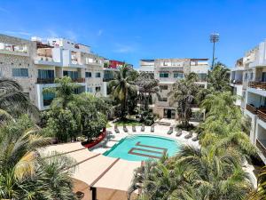un complexe d'appartements avec piscine et palmiers dans l'établissement Sabbia 4110 - 3 Bedrooms all-in suite, à Playa del Carmen