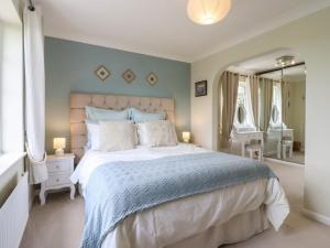 a bedroom with a large bed and a large mirror at Church Cottage in Diss