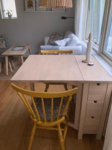 cocina con mesa, silla y sofá en Tiny grey house with loft, 15 min from city center, en Gotemburgo