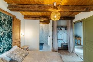 Schlafzimmer mit einem Bett mit Holzdecke in der Unterkunft Le gîte de Romain in Sanvensa