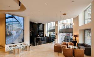 a lobby with a large screen in a building at The Square Milano Duomo in Milan