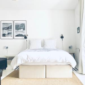 1 dormitorio blanco con 1 cama grande con sábanas blancas en The Art Room Apartment, en Cardigan