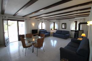 una sala de estar con sofás azules y una mesa. en Paraiso Terrenal 8 - holiday home with private swimming pool in Costa Blanca, en Benissa