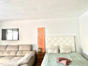 a bedroom with a bed and a couch at Villa AURA 500 metros de la playa in Torre de Benagalbón