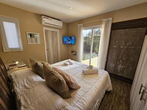 a bedroom with a bed with pillows and a window at Magnifique studio éco relaxant avec piscine in Mendoza