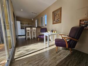 a living room and kitchen with a table and chairs at Magnifique studio éco relaxant avec piscine in Mendoza