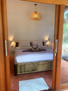 a bedroom with a bed and a glass door at Ocean Vibes in Thongsala