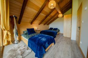 two beds in a room with wooden ceilings at Beskidzka Oaza in Istebna