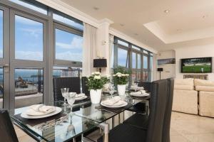 a dining room with a glass table and a couch at Luxury City Center Penthouse - Best Location in Galway