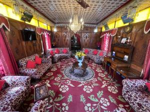 ARISTOTLE GROUP OF HOUSEBOATS & TRANSPORTATION في سريناغار: غرفة بالقطار بها كنب وطاولة