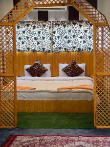 a bedroom with a bed with a wooden canopy at ARISTOTLE GROUP OF HOUSEBOATS & TRANSPORTATION in Srinagar