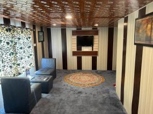 a living room with a couch and a tv at ARISTOTLE GROUP OF HOUSEBOATS & TRANSPORTATION in Srinagar