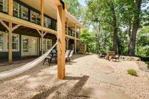 um alpendre com uma rede de descanso em frente a uma casa em Spacious Home on Beaver Lake with Deck and Fire Pit! em Rogers