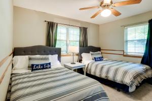 um quarto com 2 camas e uma ventoinha de tecto em Spacious Home on Beaver Lake with Deck and Fire Pit! em Rogers