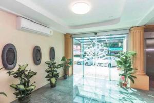 a room with potted plants in a building with a window at Leda Seaview Room in Ban Saiyuan (1)