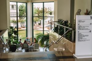 um grupo de pessoas sentadas em mesas em um edifício em Real Bellavista Hotel & Spa em Albufeira