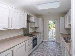 a white kitchen with white cabinets and a window at City Centre 3 BDR Townhouse by Belfast City Breaks in Belfast