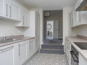 a kitchen with white cabinets and a tile floor at City Centre 3 BDR Townhouse by Belfast City Breaks in Belfast
