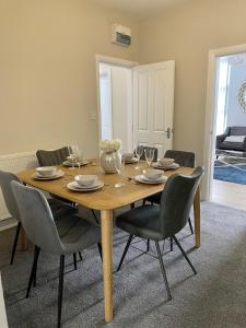 a wooden table with chairs and a dining room at City Centre 3 BDR Townhouse by Belfast City Breaks in Belfast