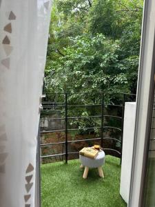 un taburete sentado en el césped fuera de una ventana en Sofo house, en Sofía