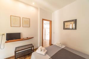 um pequeno quarto com uma cama e uma televisão em Borgo Marino Plemmirio em Siracusa