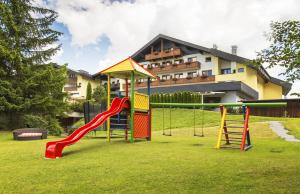 un parque infantil frente a un edificio con tobogán en Bergresort Seefeld, en Seefeld in Tirol