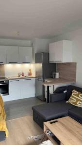 ein Wohnzimmer mit einem Sofa und einer Küche in der Unterkunft Chic & moderne appartement - proximité métro in Asnières-sur-Seine