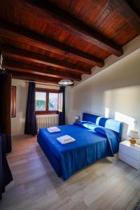 a bedroom with a blue bed and wooden ceilings at Agriturismo Case Rapputi in Lascari