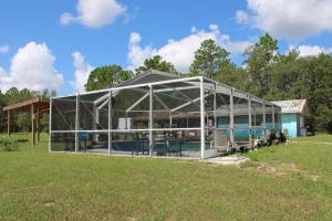 a large greenhouse in a field in a yard at Mermaid Manor in Homosassa
