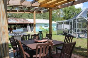 a wooden table and chairs under a wooden pergola at Mermaid Manor in Homosassa