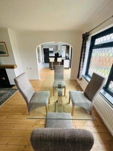 a living room with chairs and a couch and a mirror at Cherry Cottage in West Mersea
