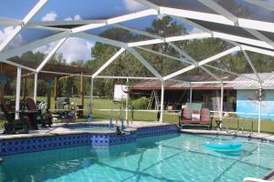 a swimming pool with a pavilion and a swimming poolvisor at Mermaid Manor in Homosassa