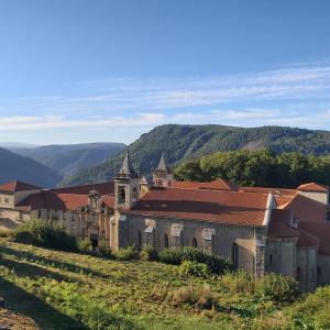an old building on a hill with mountains in the background at Casa das Peleteiro Ribeira Sacra in Ourense