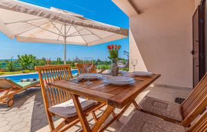 un tavolo in legno con sedie e ombrellone di Villa Barbara a Pakovo Selo