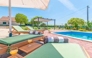 una piscina con due lettini e un ombrellone di Villa Barbara a Pakovo Selo
