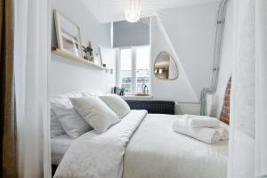 a white bedroom with a white bed with white pillows at Tempus Te Avangard Tallinn with terrace and gym in Tallinn