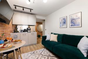 a living room with a green couch and a table at Tempus Te Avangard Tallinn with terrace and gym in Tallinn