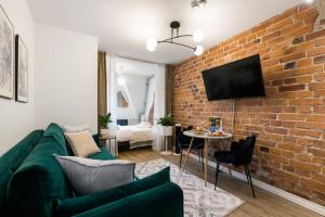 a living room with a green couch and a brick wall at Tempus Te Avangard Tallinn with terrace and gym in Tallinn