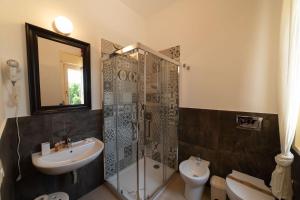y baño con lavabo, ducha y aseo. en Borgo Marino Plemmirio, en Siracusa