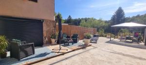 a patio with a bunch of chairs and an umbrella at appartement cosy in Feigères