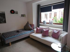 ein Wohnzimmer mit einem Sofa und einem Fenster in der Unterkunft Apartementhaus Gneisenaustraße in Bremen