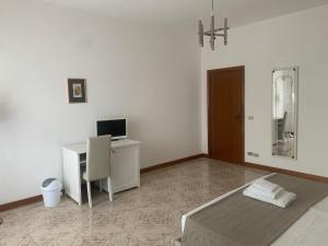 a bedroom with a bed and a desk with a computer at Porta Napoli Rooms in Lecce