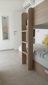 1 dormitorio con litera de madera y 1 habitación en AltamareA Casa vacanze en Brucoli