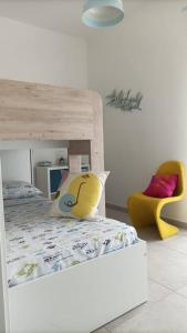 um quarto com um beliche e uma cadeira amarela em AltamareA Casa vacanze em Brucoli