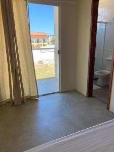 Habitación vacía con puerta y aseo en POUSADA RECANTO DULE en Guarapari