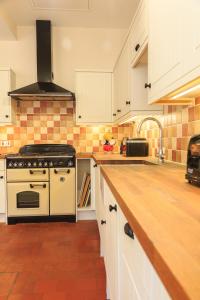 a kitchen with white cabinets and a stove top oven at The Old Chemist in Burley