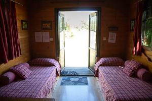 2 camas en una habitación con puerta abierta en LA ROULOTTE, en Pondaurat