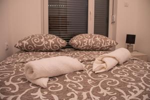 un letto con due cuscini e due asciugamani sopra di Vasilije a Vrnjci